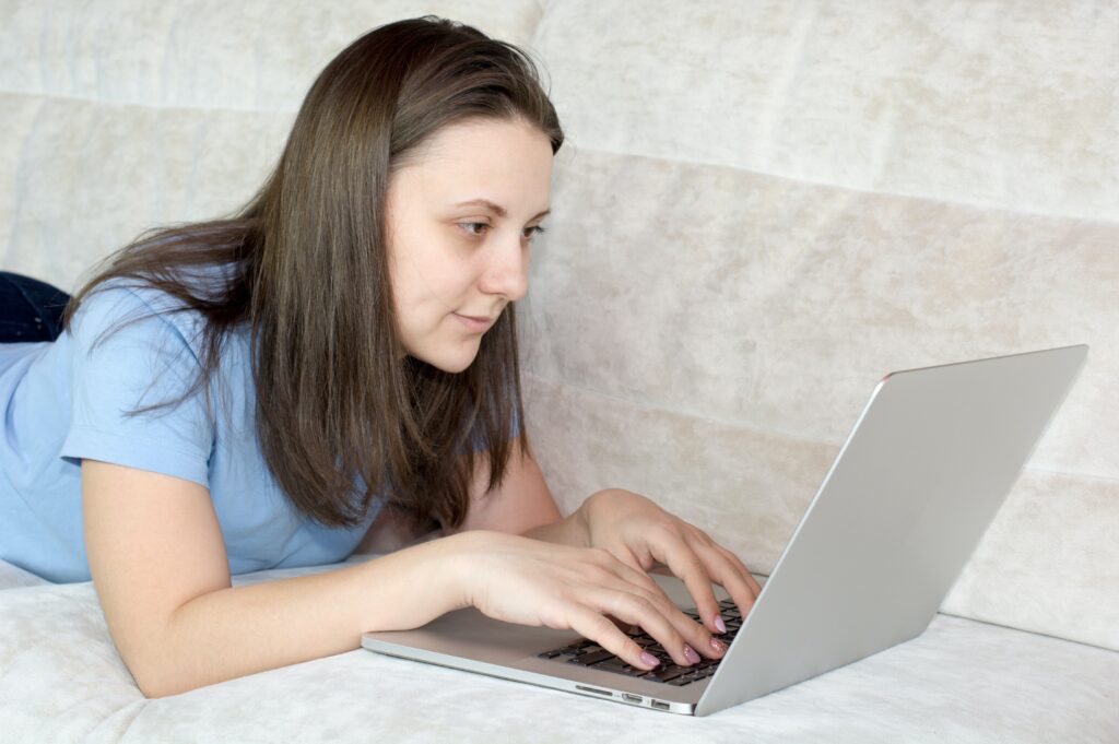 woman in blue shirt using macbook air