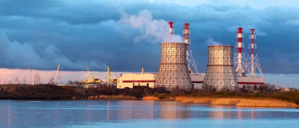 white and red tower near body of water under blue sky during daytime