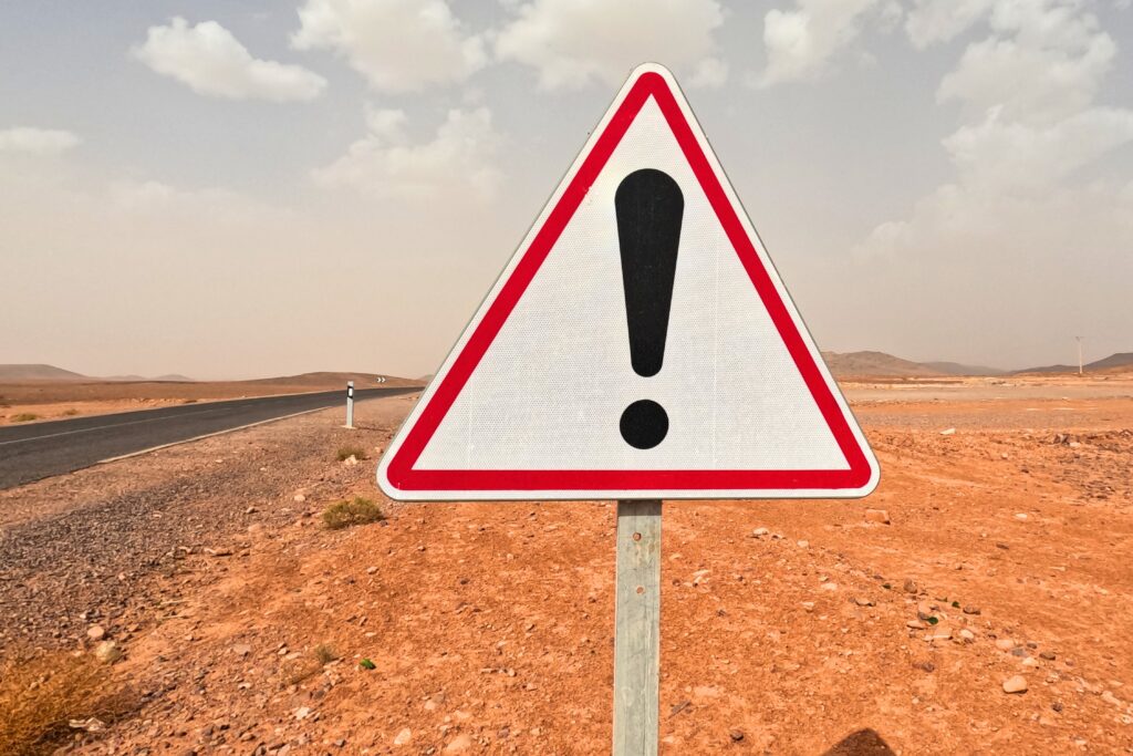 Dopravní značka s vykřičníkem u cesty