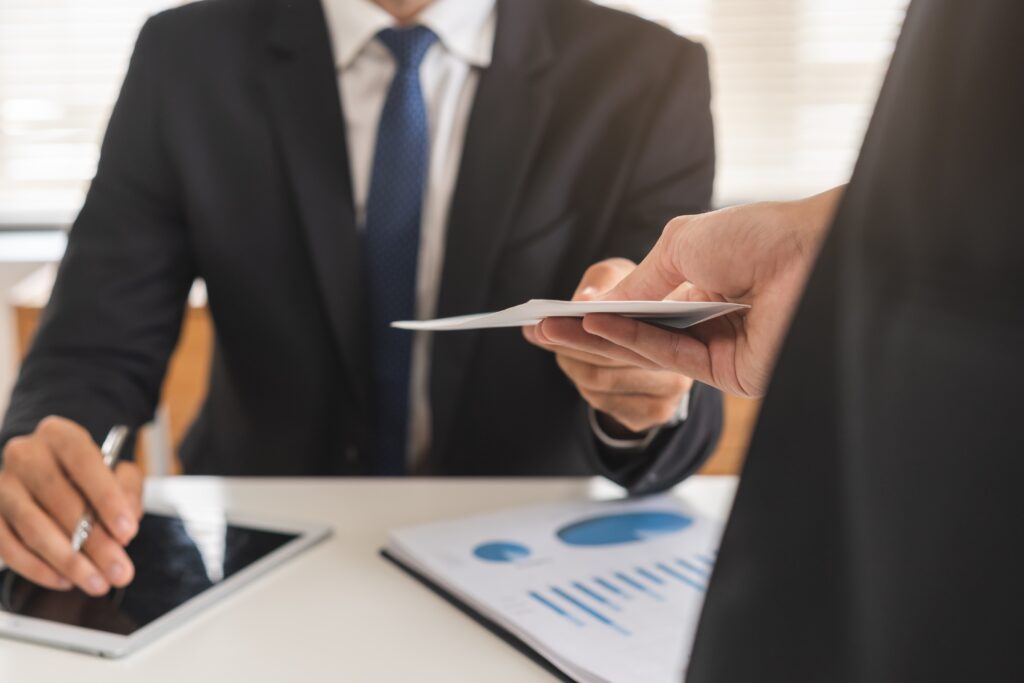 Dva muži ve firmě si předávají dokument