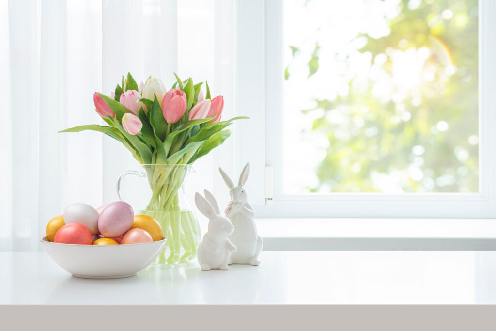 Velikonoční zátiší - mísa s vajíčky, váza s tulipány a keramičtí zajíčci