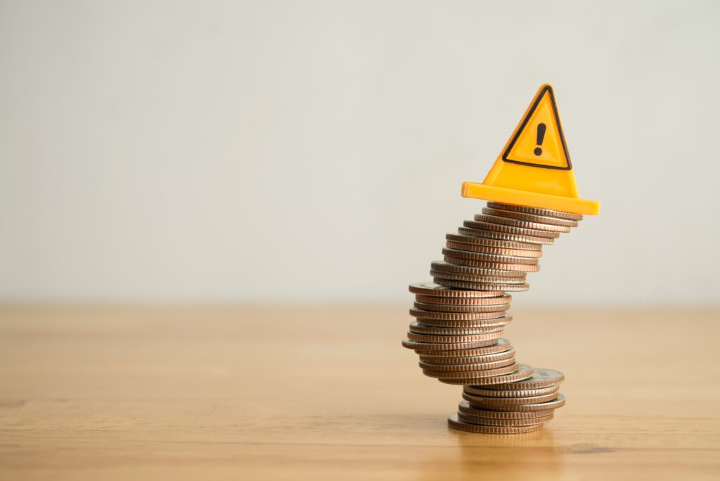 Mince na stole poskládané do komínku, na nich vykřičník