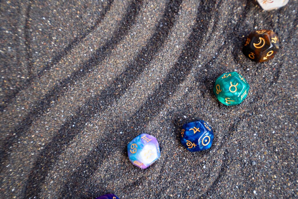 Minerální kameny se znaky astrologických znamení v písku