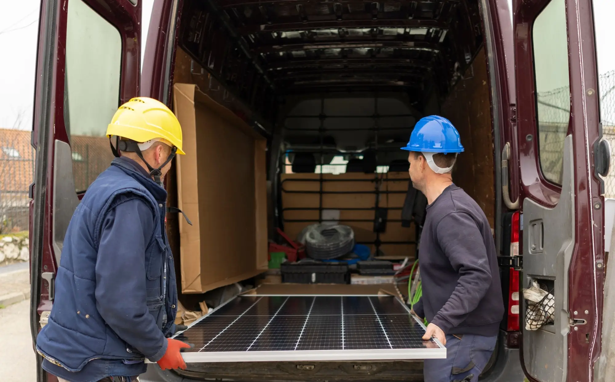 Pracovníci vyndávají z dodávky solární panel