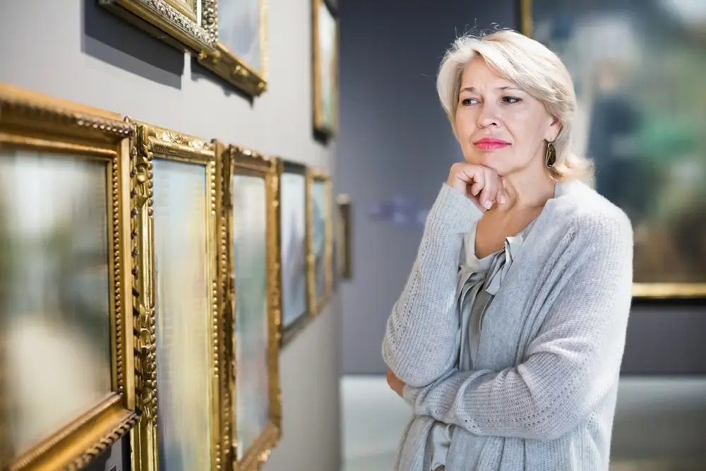 Žena se dívá na staré obrazy.