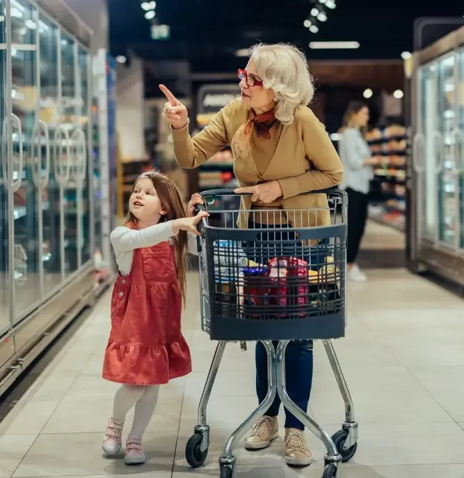 Důchodkyně s vnučkou v obchodě.