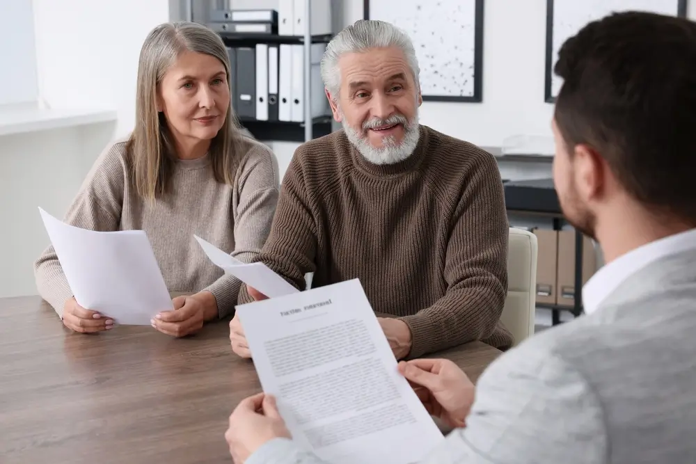 Starší muž je se svou ženou na schůzce s finančním poradcem. 