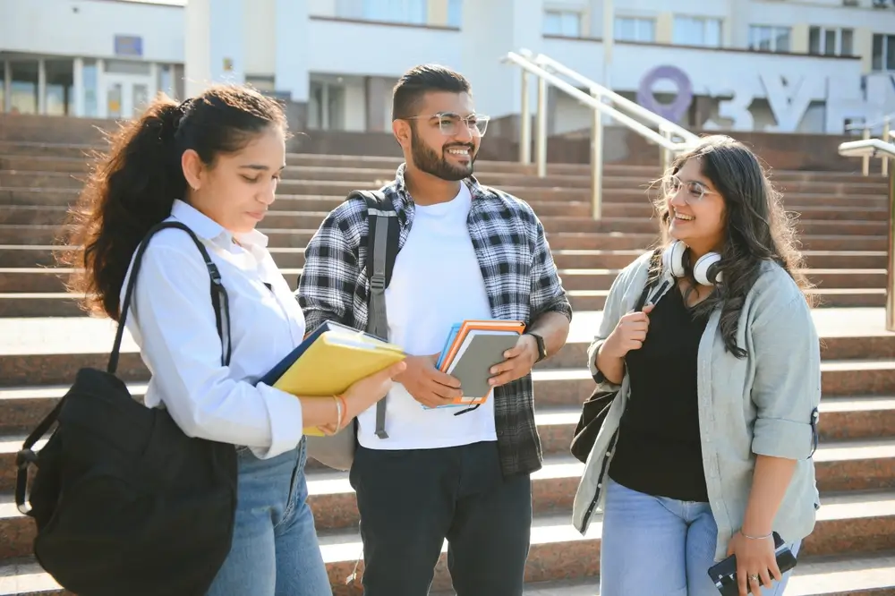 Tři studenti u univerzity.