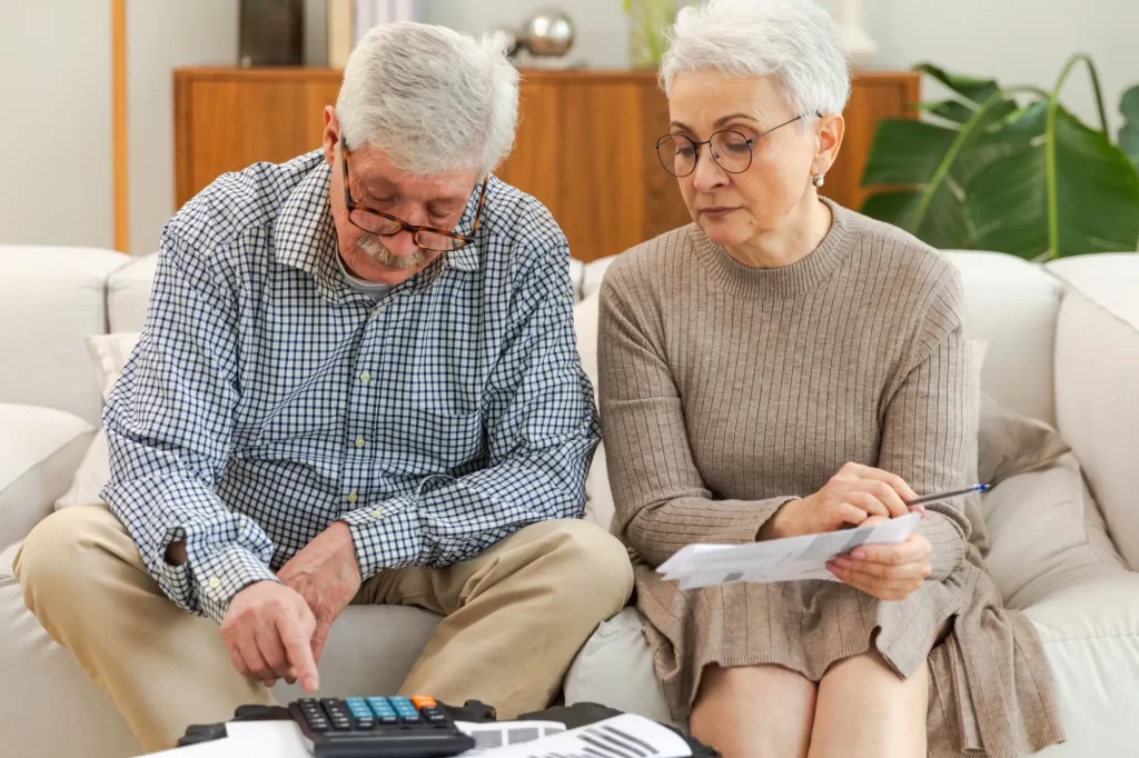 Starší muž a žena počítají na kalkulačce