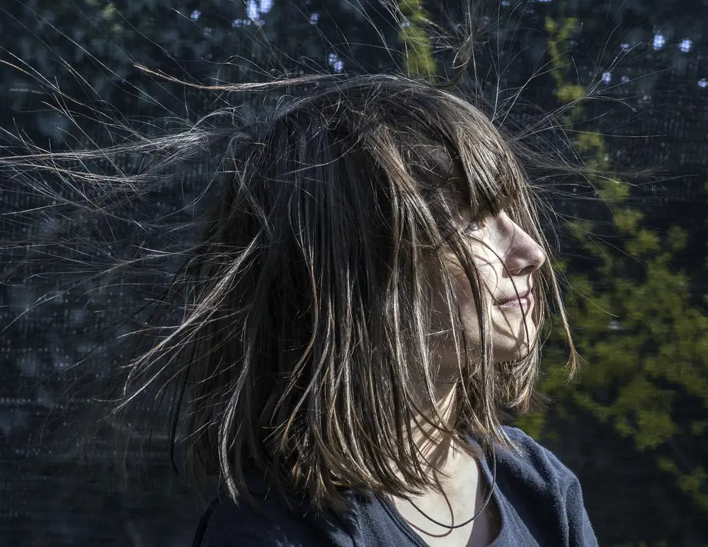 Žena má zelektrizované vlasy.