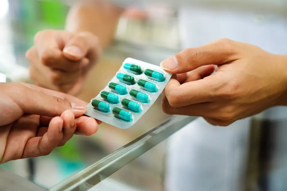 Lékárnice podává pacientovi antibiotika.