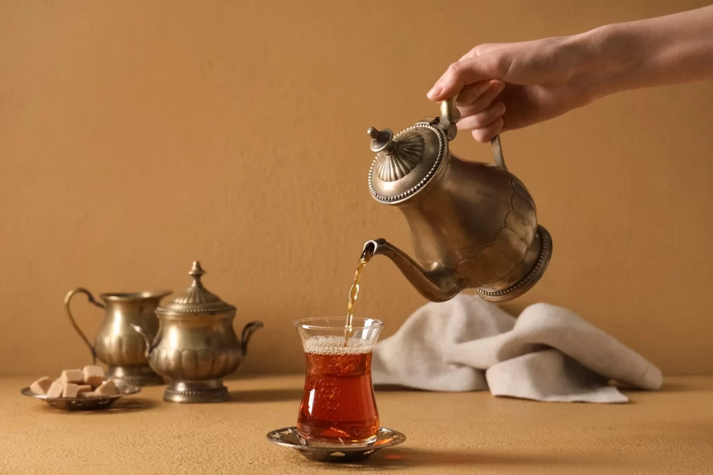 Nalévání čaje z konvičky.