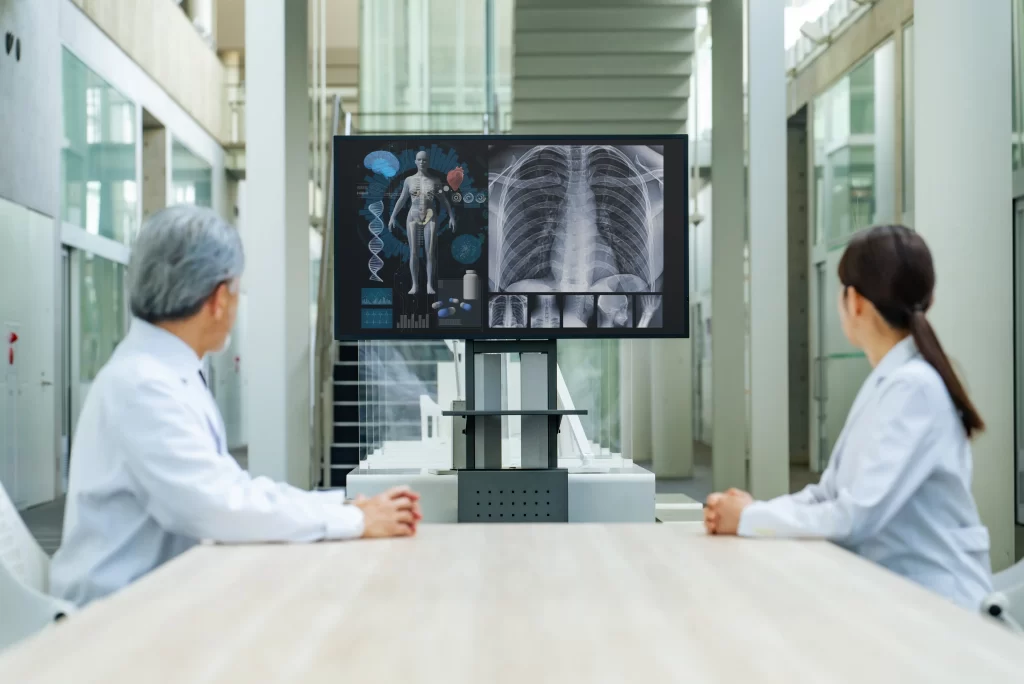 Dva l&eacute;kaři, kteř&iacute; se d&iacute;vaj&iacute; na rentgen.