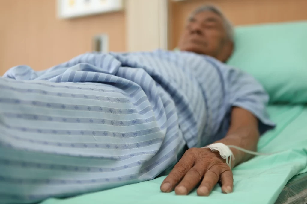 Star&scaron;&iacute; muž lež&iacute;c&iacute; v nemocnici. 