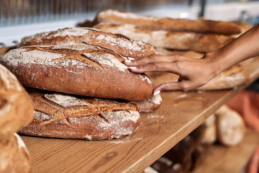 Žena sah&aacute; na pečivou holou rukou. 
