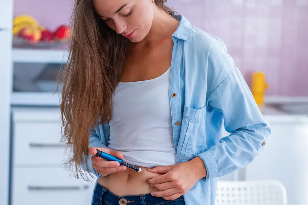 Žena s píchá inzulín.