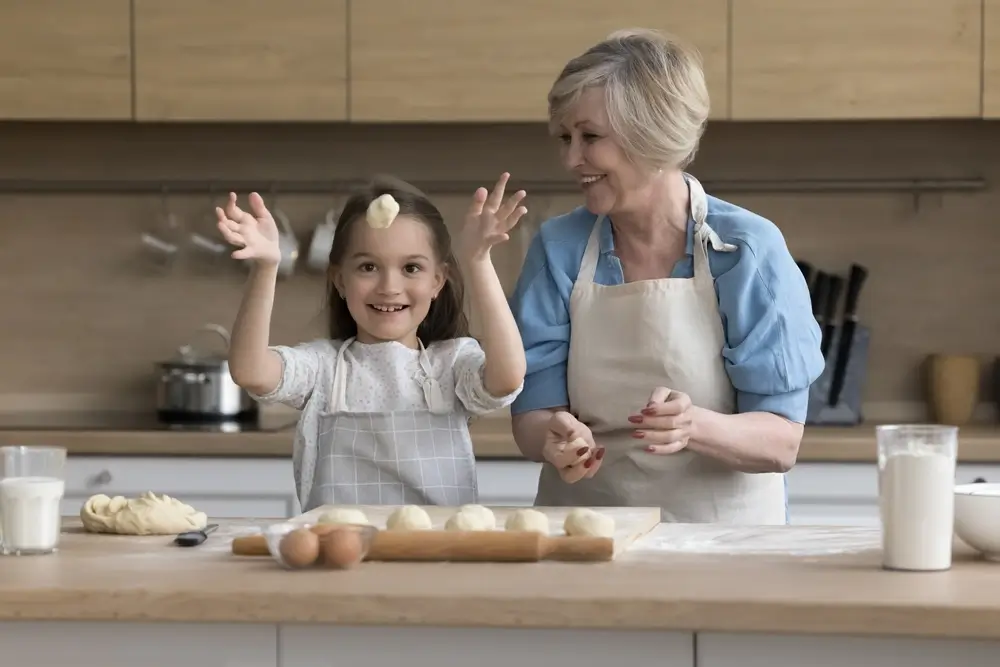 Žena s vnučkou připravují jídlo.