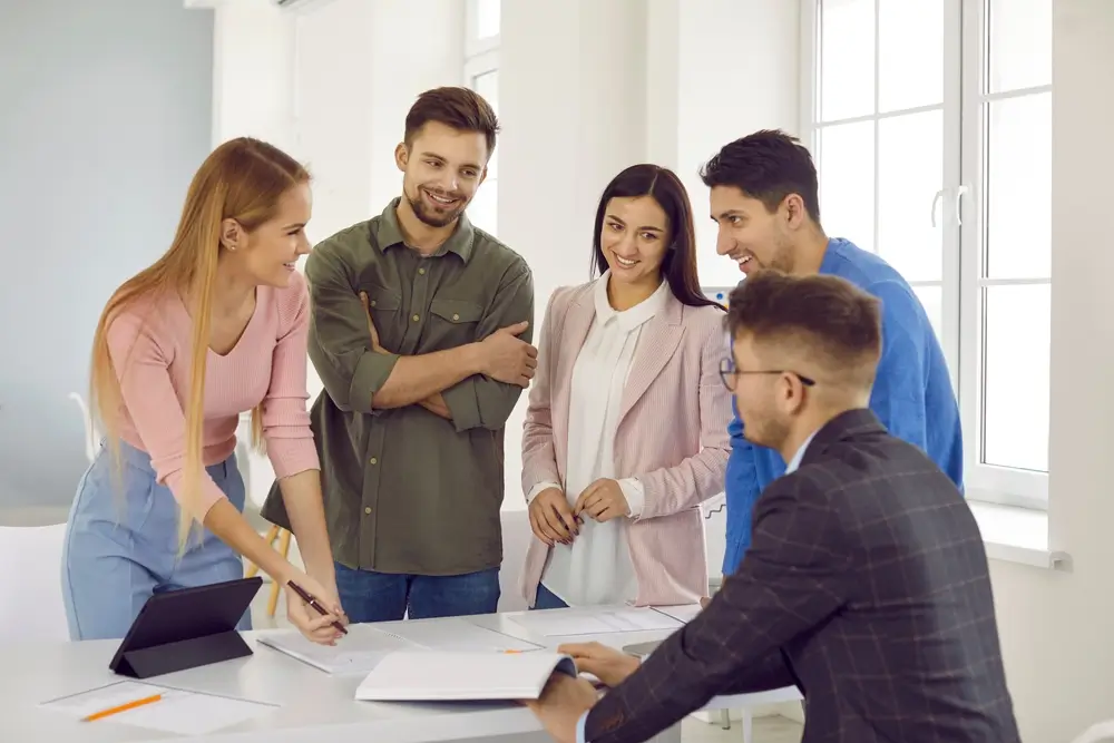 Muž něco vypráví svým 4 kolegům v práci.