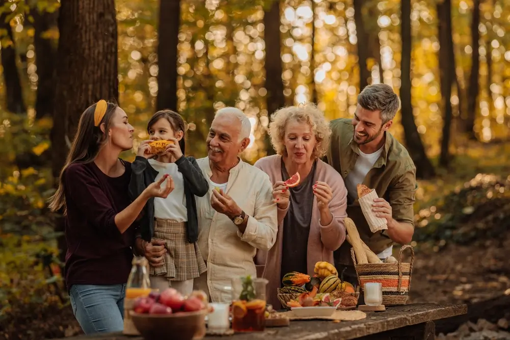 Rodina, která pořádá piknik uprostřed lesa.