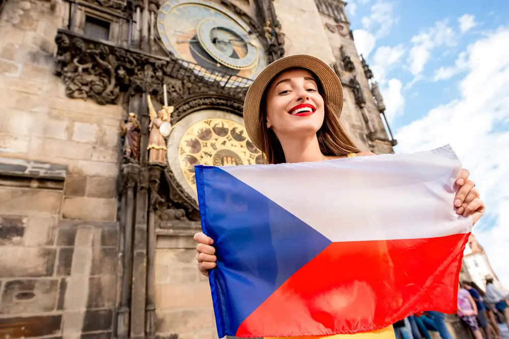 Žena drží českou vlajku.