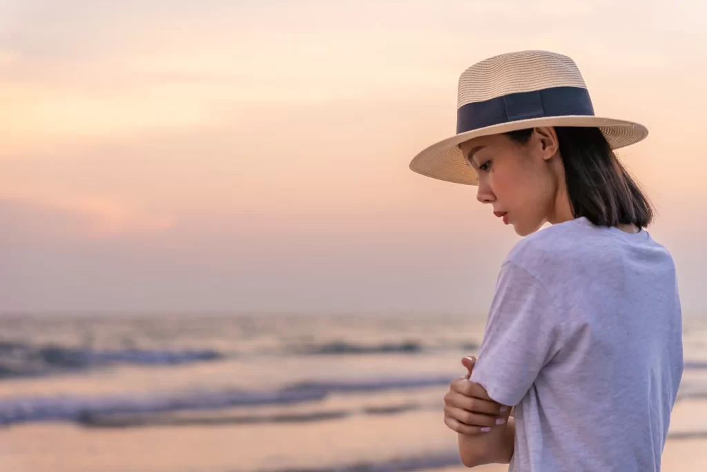 Zamy&scaron;len&aacute; žena na pl&aacute;ži. 