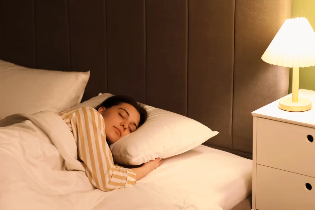 Žena sp&iacute;c&iacute; s rozsv&iacute;cenou lampičkou.