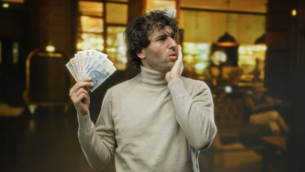 Zamyšlený muž s penězi v ruce.
