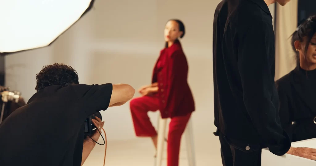 Fotoaparát před kterým stojí žena.