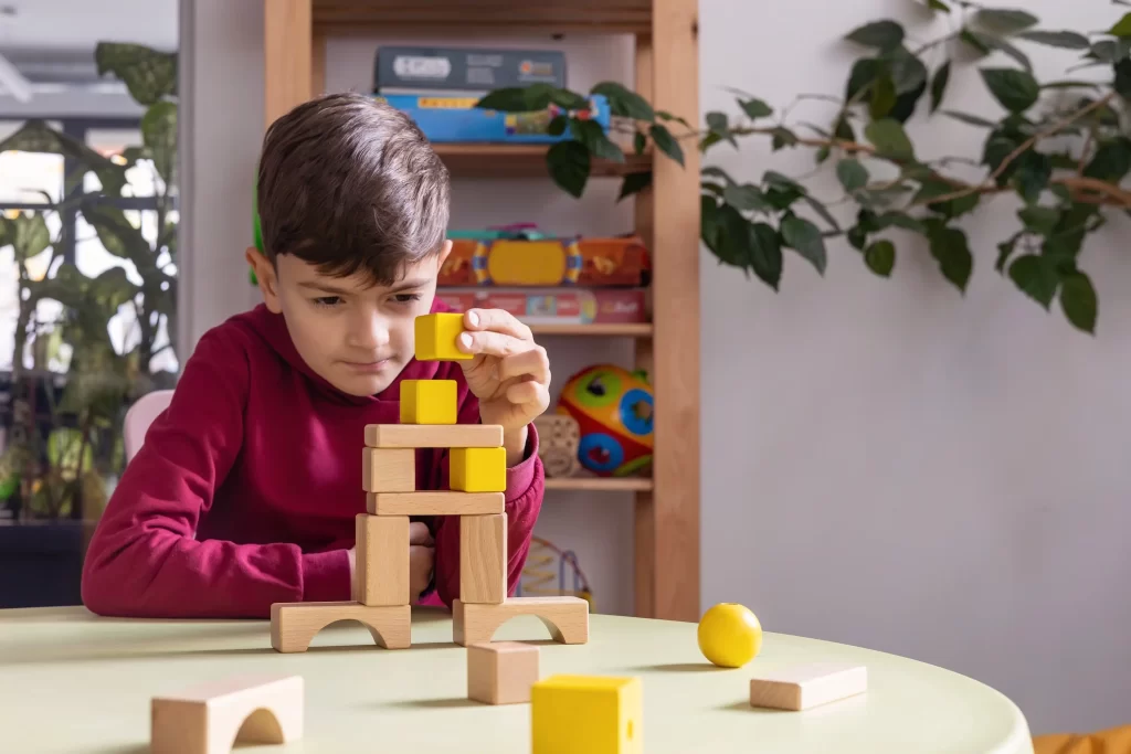 kluk si stav&iacute; z kostek