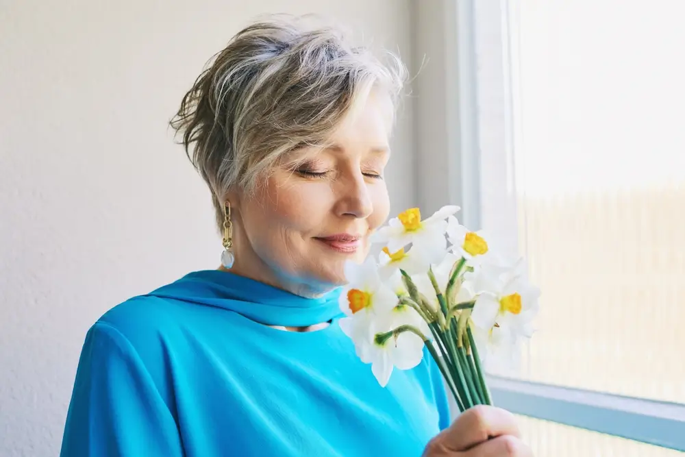 Žena čichá ke květinám. 