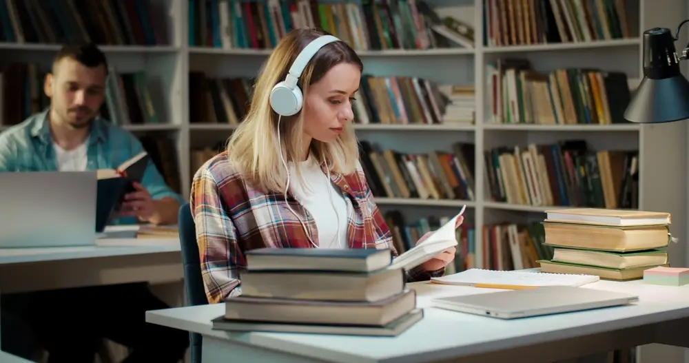 Žena a muž se učí v knihovně. 