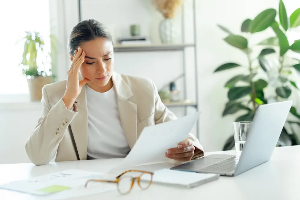 Frustrovaná žena v práci u notebooku. 