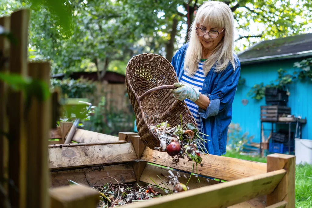 Žena dávající zbytky do kompostu.