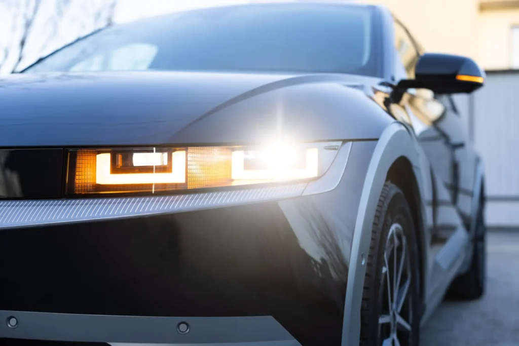 Detail modern&iacute; LED světlometu na čern&eacute;m automobilu