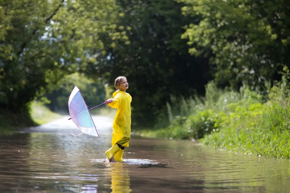 Malá holčička si hraje v dešti