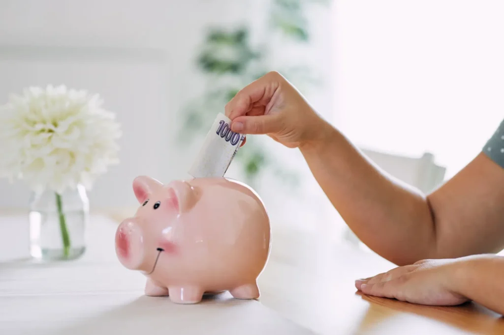 Žena strká do prasátka tisícikorunu