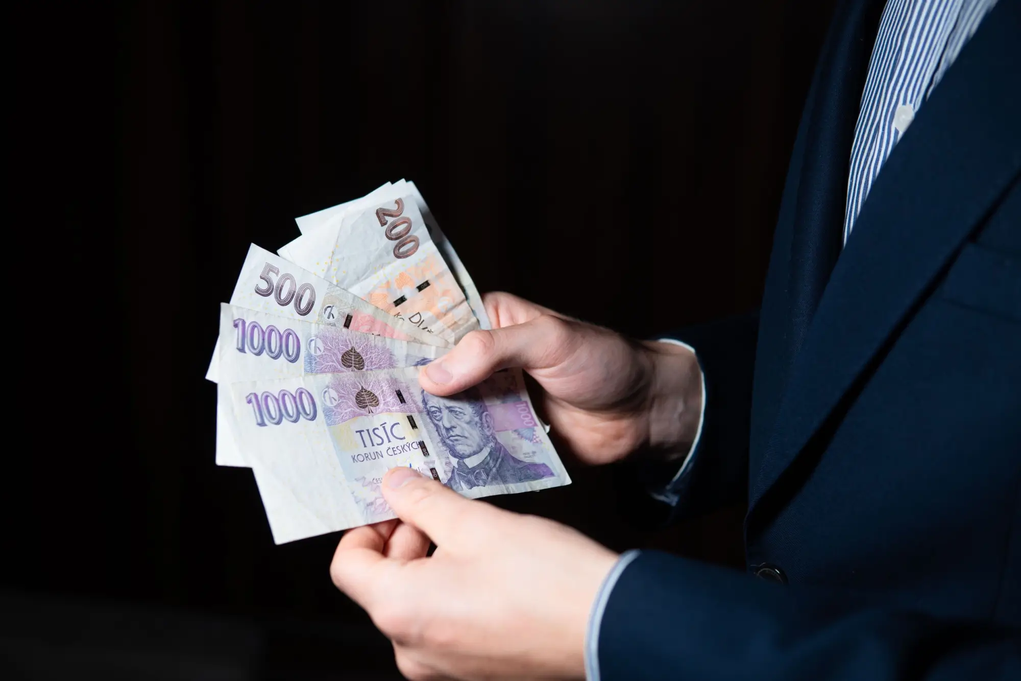 Muž v obleku se svazkem peňez