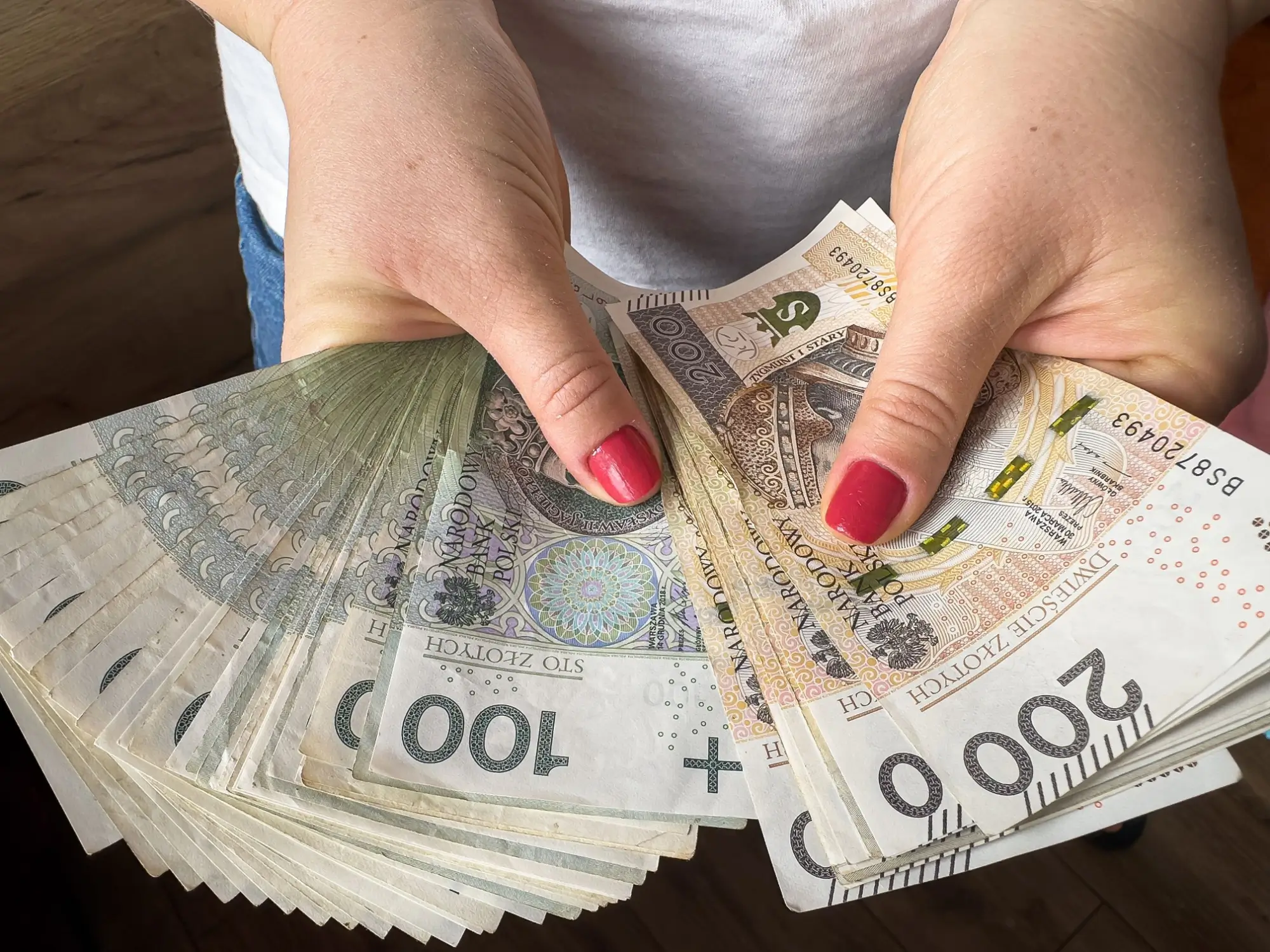 Ženské ruce držící bankovky podle hodnoty.