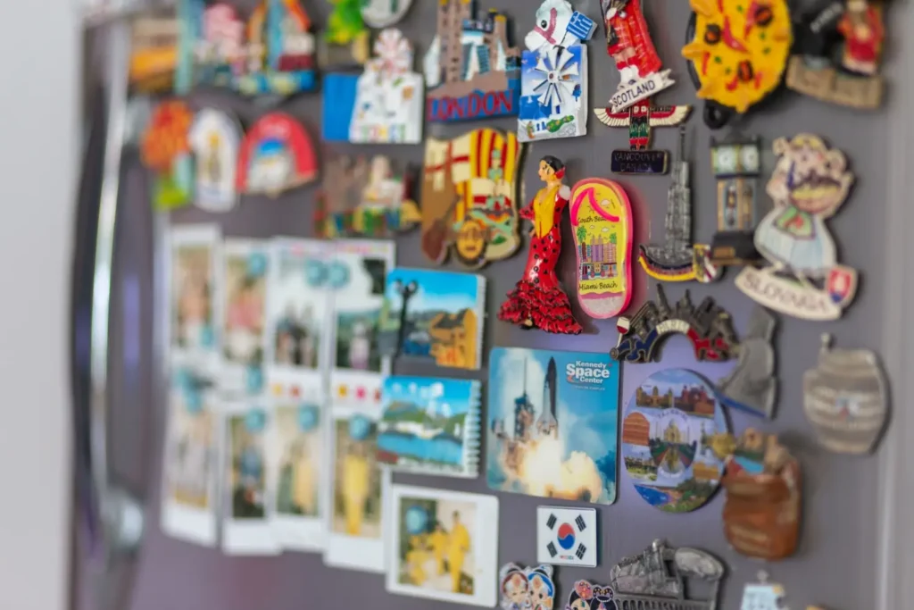 Barevn&eacute; suven&yacute;rov&eacute; magnetky z různ&yacute;ch měst na lednici