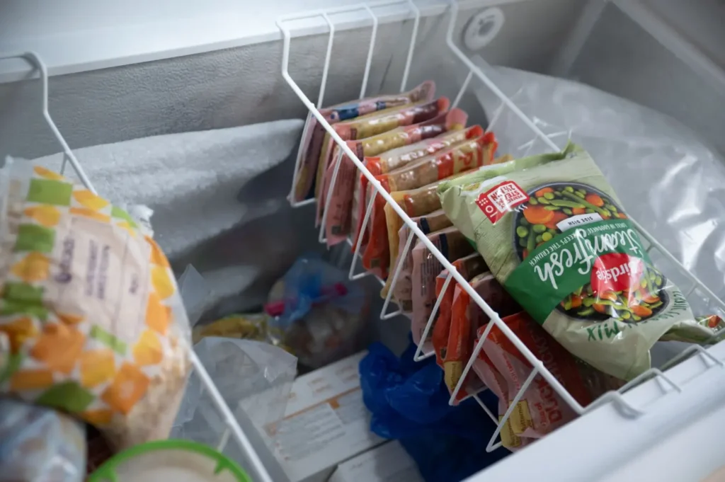 Otevřený pultový mrazák naplněný mraženými potravinami