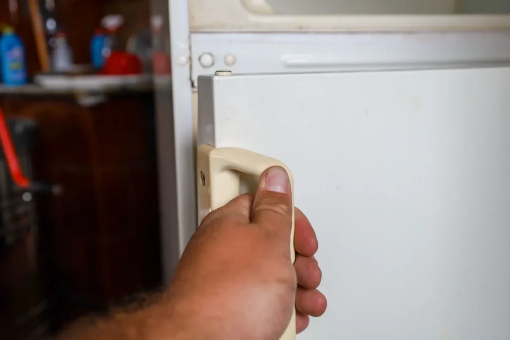 Ruka otev&iacute;r&aacute; starou lednici