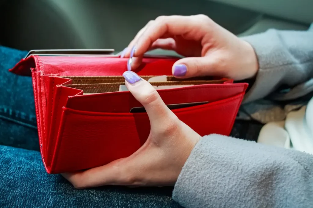 Detail ženy s otevřenou červenou peněženkou