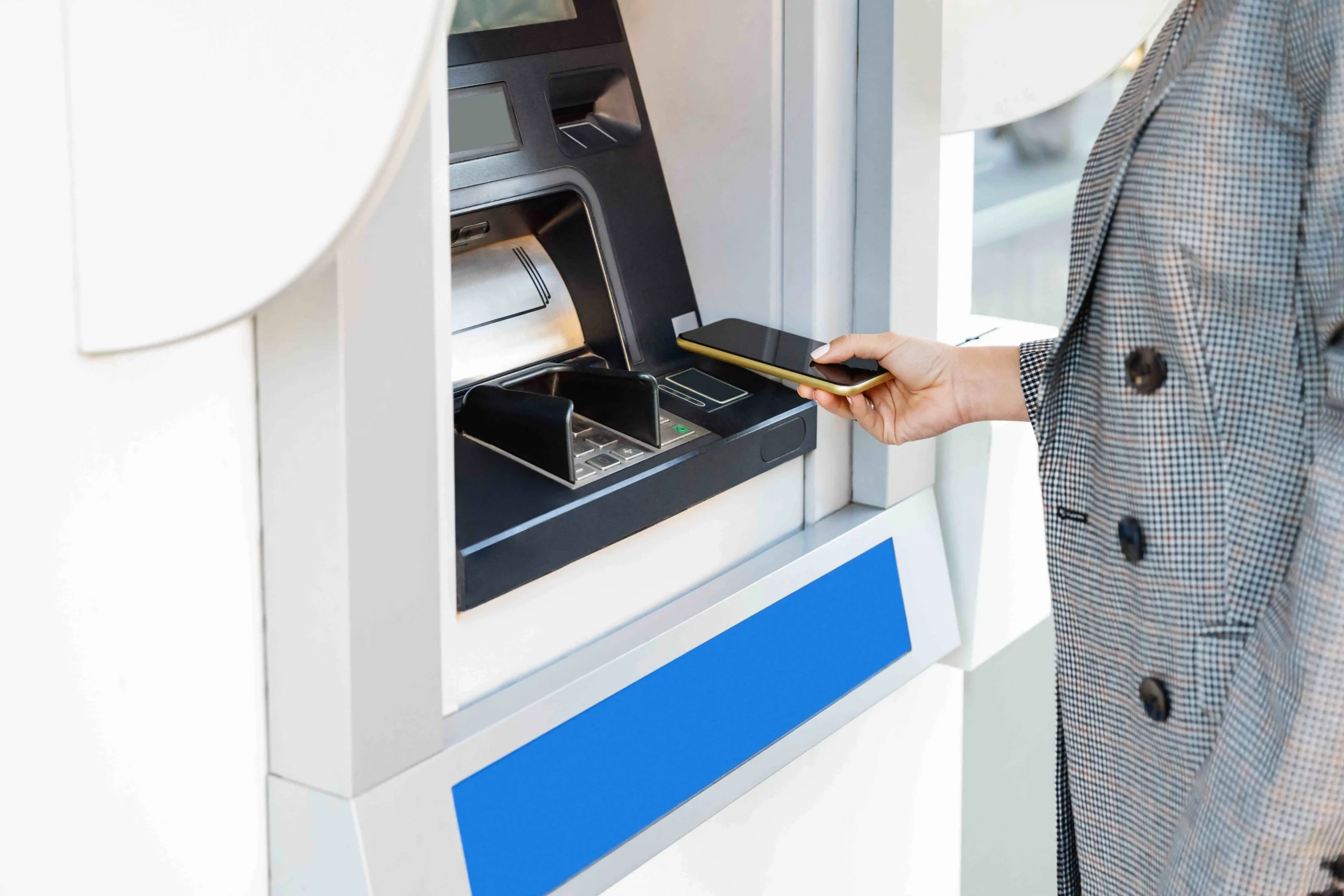 Žena vyb&iacute;r&aacute; z bankomatu pomoc&iacute; mobilu