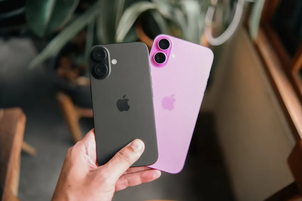Osoba drž&iacute; v ruce &scaron;ed&yacute; a růžov&yacute; iPhone