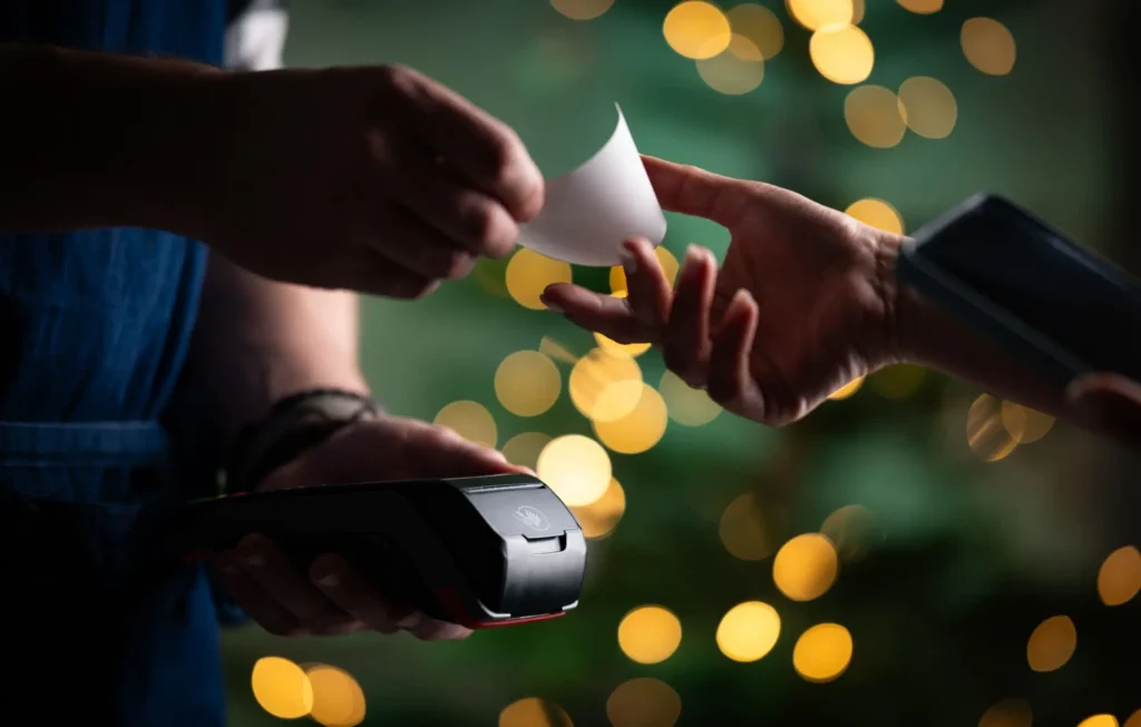 Prodejce před&aacute;v&aacute; &uacute;čtenku z&aacute;kazn&iacute;kovi