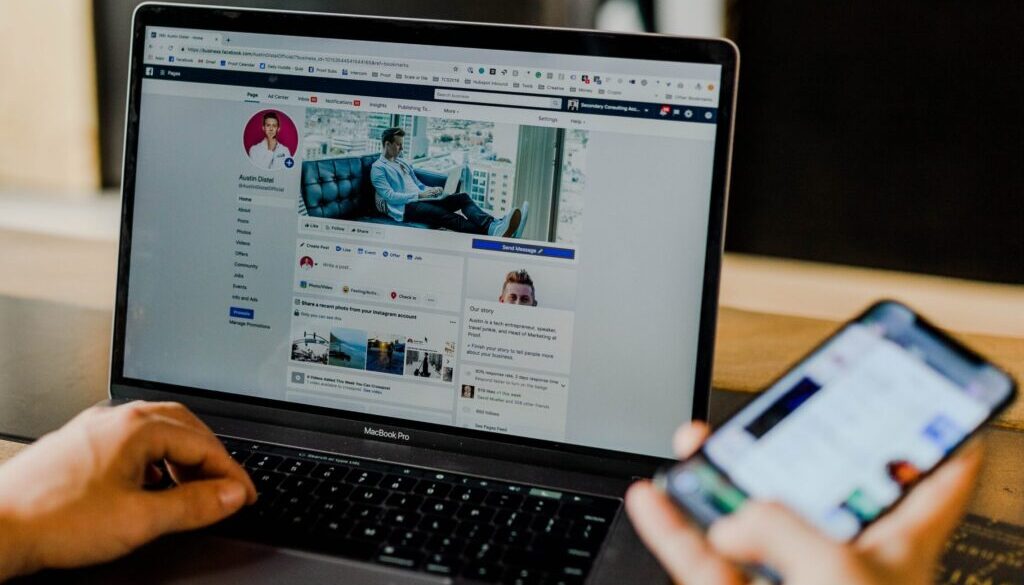 person using both laptop and smartphone