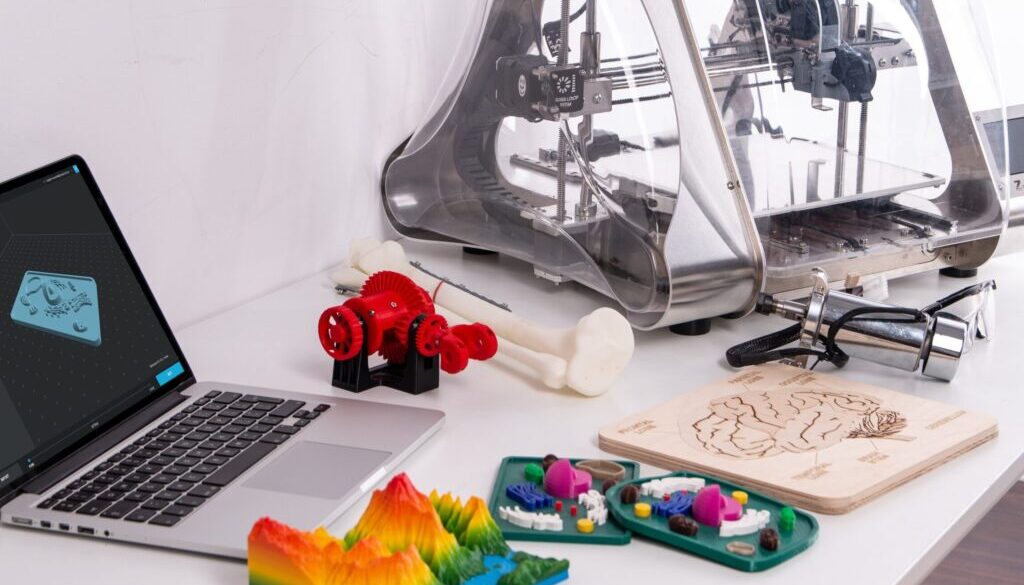 MacBook Pro beside 3D printer
