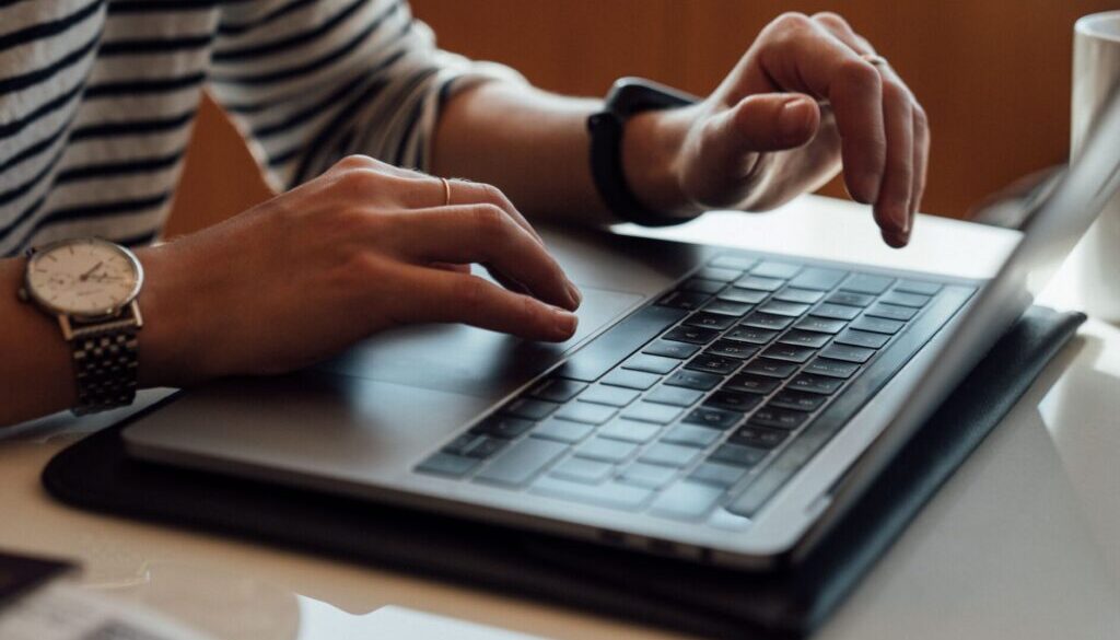 person seated at the table using laptop