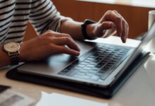 person seated at the table using laptop