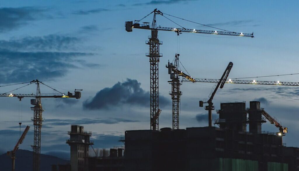 several cranes above the buildings